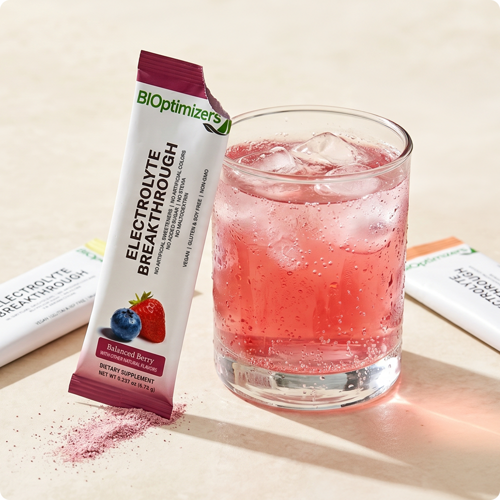 Electrolyte Breakthrough Balanced Berry stick pack beside a glass of mixed electrolyte drink